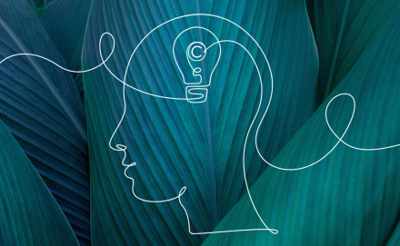 Drawing of a Human Head and a Lightbulb on a Green Abstract Background