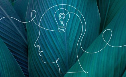 Drawing of a Human Head and a Lightbulb on a Green Abstract Background