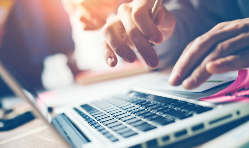 Person typing on laptop close-up